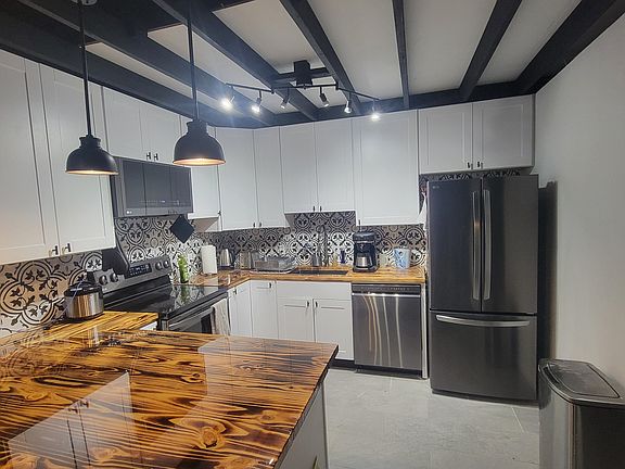 Open layout for kitchen with new SS LG appliances and modern farmhouse design.