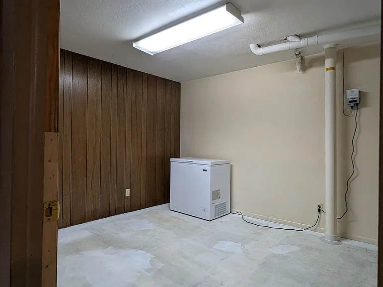 Downstairs utility room with freezer included. Concrete floors.