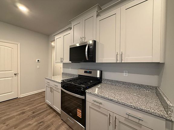 Granite Countertops, Stainless Steal Appliances and overview of breakfast area, living room and covered porch