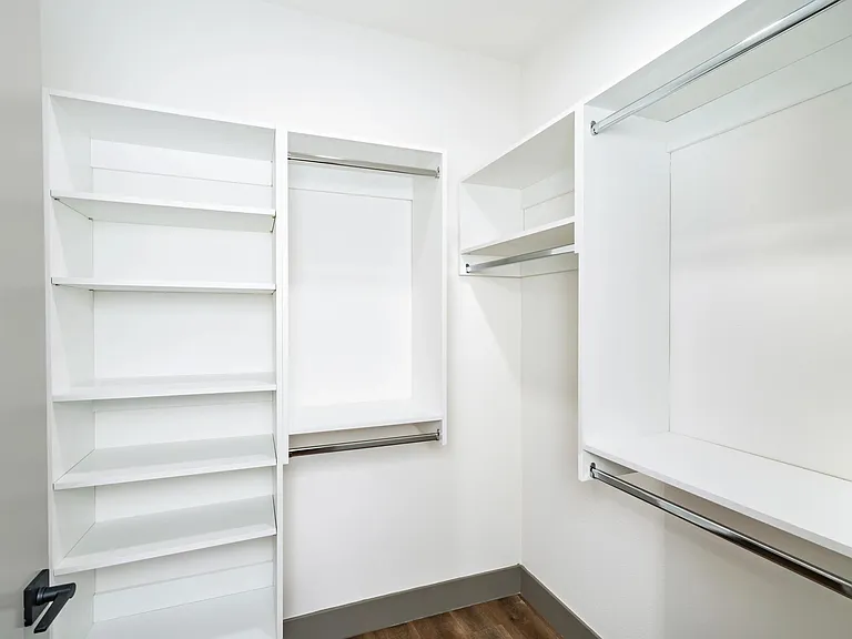 A spacious closet with built-in shelving and plenty of room to organize.