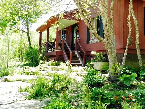 Large stone steps with perennial landscaping lead to side entry of mud room & powder room.