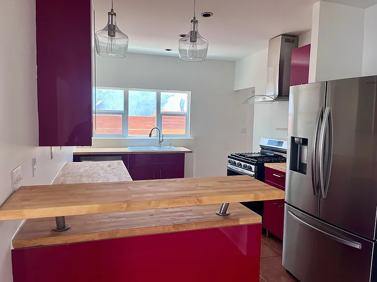 The kitchen with stainless steel appliances throughout (refrigerator, dishwasher, gas range/oven and a microwave)
