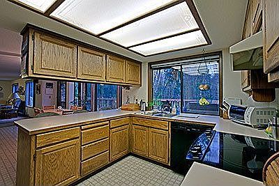 Kitchen overlooks serene wooded setting;opens to dining nook & family room
