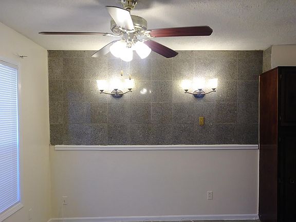 Dining Room with luxurious GRANITE tile on the wall and decorative wall sconces.