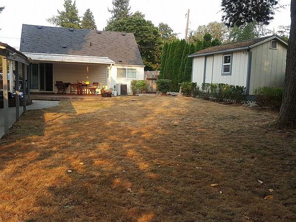 back yard. covered porch, small garden shed on right, larger garage on left