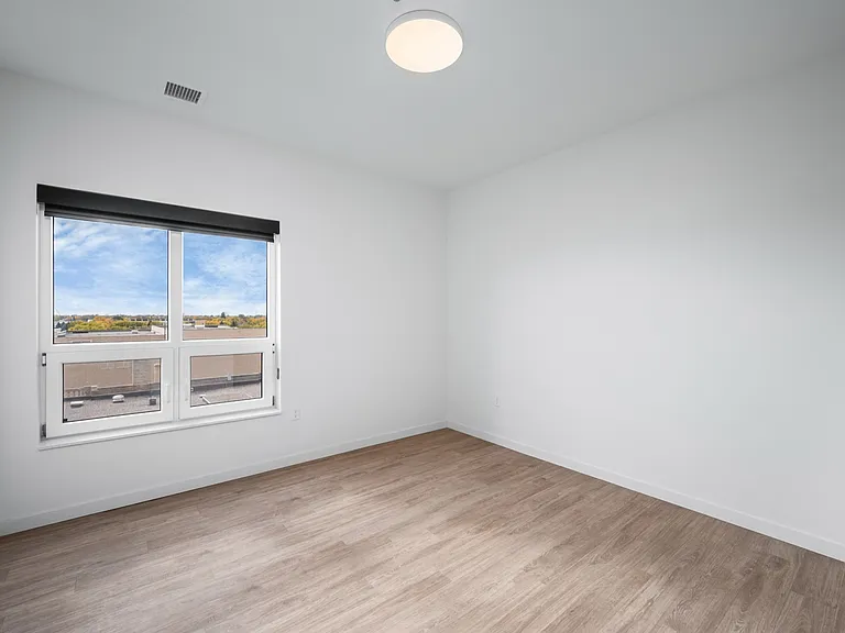 Bright and airy room with large window and sleek wooden flooring, offering a serene view of the outdoors. Bright and airy room with large window and sleek wooden flooring, offering a serene view of the outdoors.