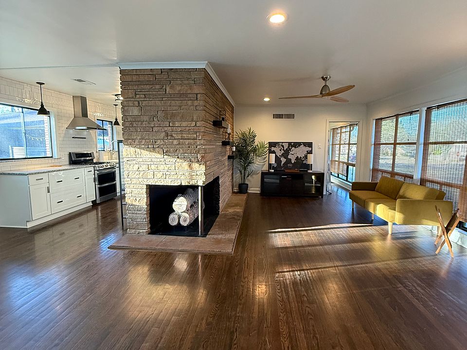 Kitchen/Dining/Living Room- 
Original Oak Hardwood Floors, Linear Stone Gas Fireplace, Recessed Lighting, Black Metal Grid Windows.