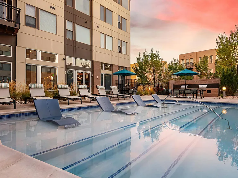 Relaxing Pool Scene with In-Water Recliners and Umbrellas
