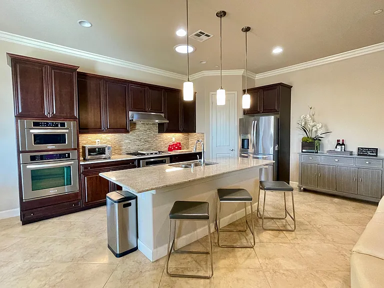 Fully stocked Chef's kitchen including quality stainless double ovens, built-in microwave, gas six-burner cooktop, Breville counter oven, vent hood, dishwasher, under-mount double basin sink and French door refrigerator all topped with granite counters. A