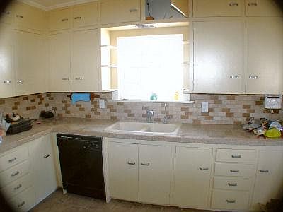 Kitchen with granite counter top, tile backsplash, lots of cabinets and drawers, tile floor