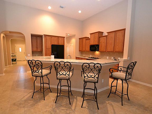 Breakfast bar opening to the kitchen offering tile floors, granite counter tops, gas range, built-in
