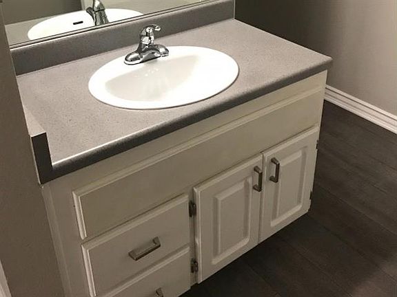 Newly renovated bathroom w/ white cabinets & grey countertop