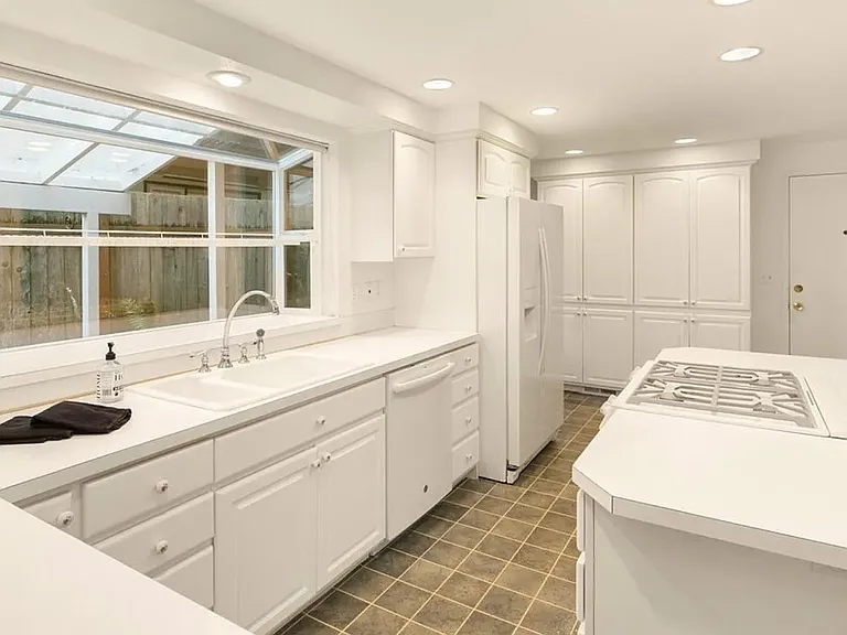 Pristine kitchen with ample storage and gas cooking.