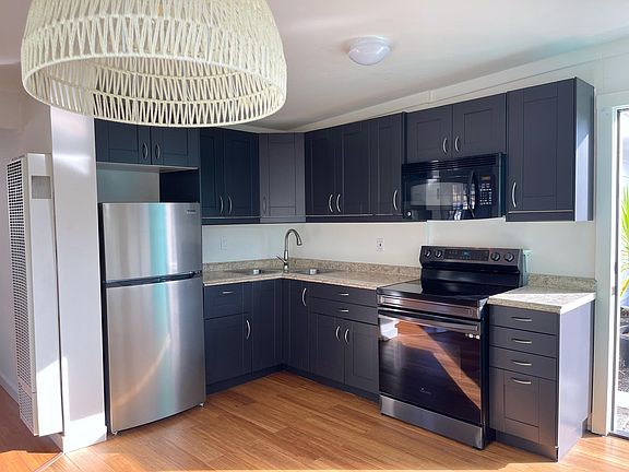 Kitchen with newly painted cabinets in a beautiful black with matching updated stainless steel appliances.