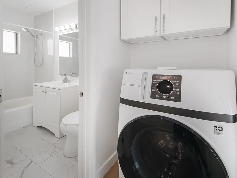 Renovated bathroom with full size bathtub // washer and dryer combo