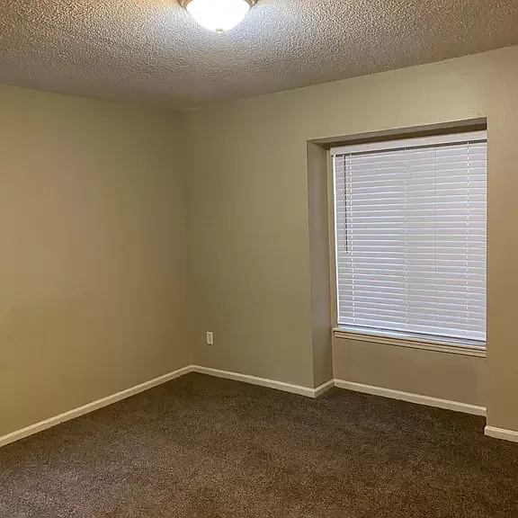 Master bed with new carpet and privacy blind
