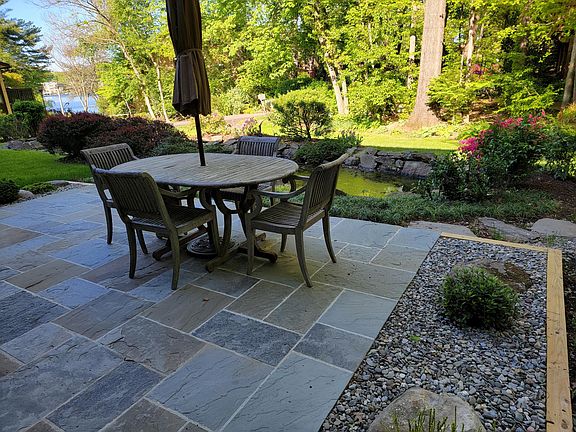 Walk-out patio from 2 sets of double sliding doors, with pond and forest in background and RA path with a view of Lake Thoreau.