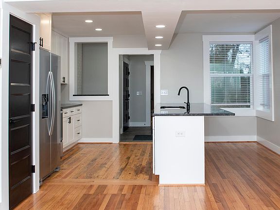 Kitchen view from living room (pantry is the black door on the left)