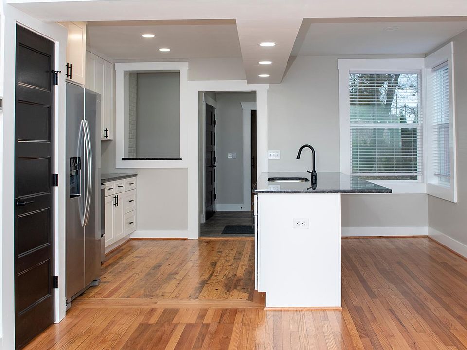 Kitchen view from living room (pantry is the black door on the left)