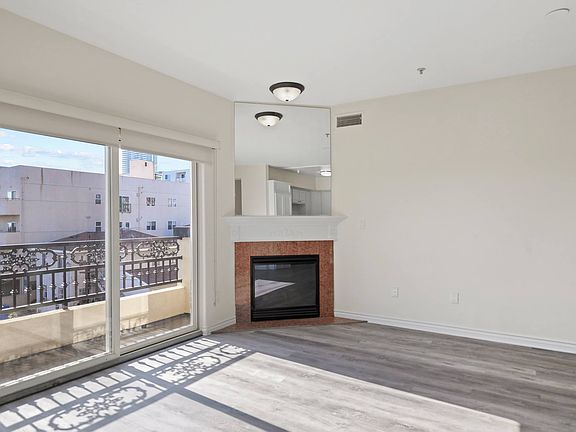 Bright Living Room Space with an Electric Fireplace and Private Balcony