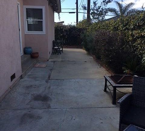 backyard cemented with flower boxes, window to master bedroo