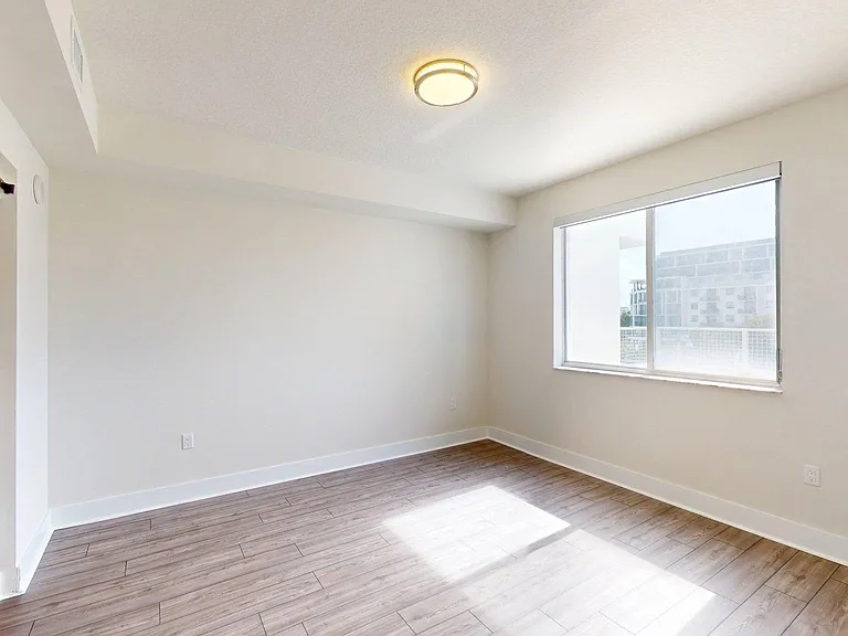 Apartment bedroom with wood style floor.