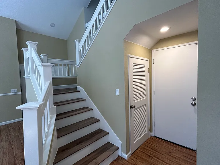 Downstairs deep closet, stairs and door towards garage