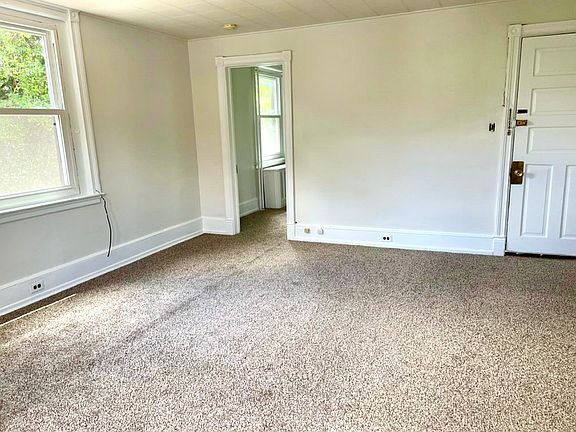 Large living room, front door on the right and bedroom on the left