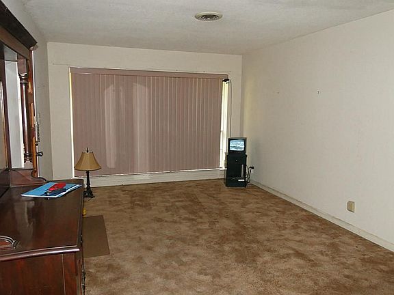 LOOKING INTO THE LARGE LIVING ROOM WITH FLOOR TO CEILING WINDOWS OVER LOOKING FRONT YARD