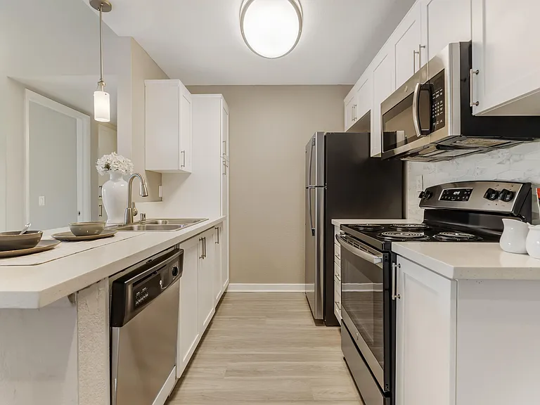 Enjoy cooking in your renovated kitchen featuring stainless steel appliances, a built-in microwave, refrigerator, dishwasher, and in-home washer and dryer for added convenience and modern comfort.