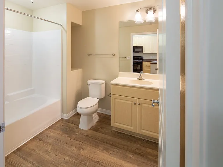 Bath with oak cabinetry, white countertop, and hard surface flooring