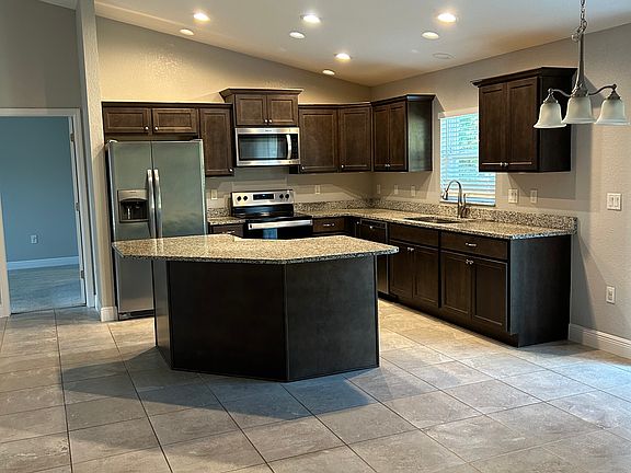 View of open kitchen plan with stainless steel refrigerator