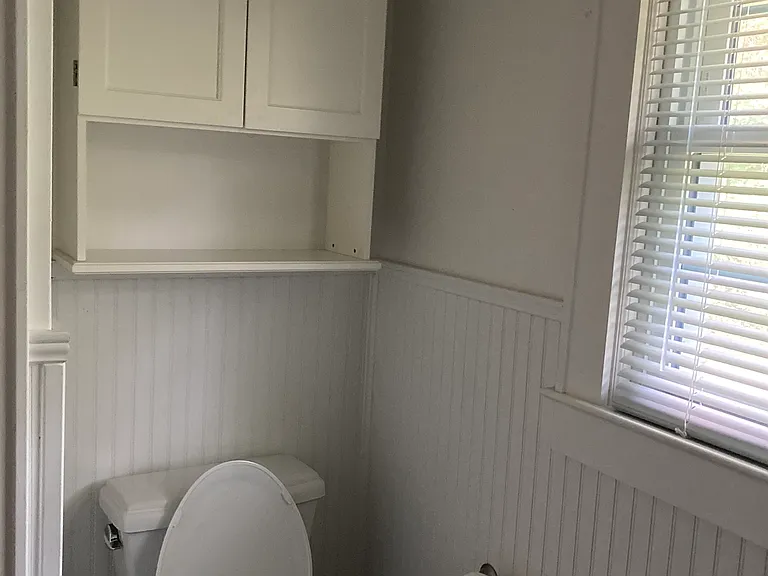 Toilet with storage cabinet.