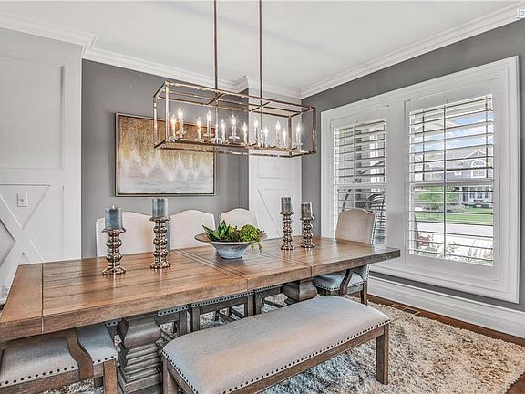Lovely dining room, note the custom plantation shutters, farmhouse trim details, hardwoods and lighting.