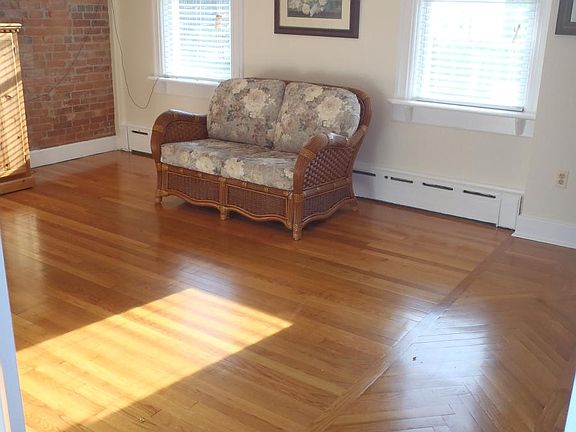 Living room with brick wall & hardwood floor