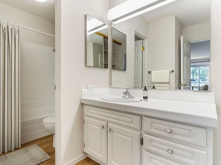 Classic Package II bath with white tile countertop, white cabinetry, and hard surface flooring