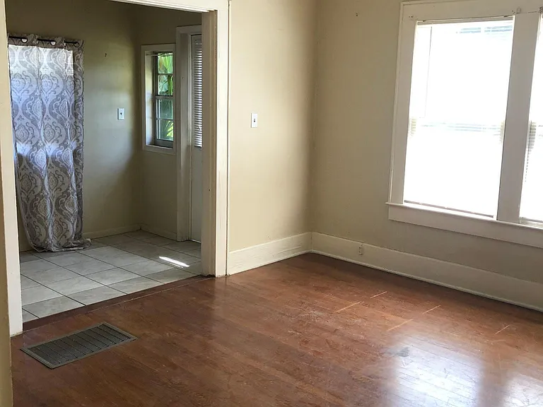 Living room with attached sun porch that can serve as office space. Hardwood floors and fresh paint.