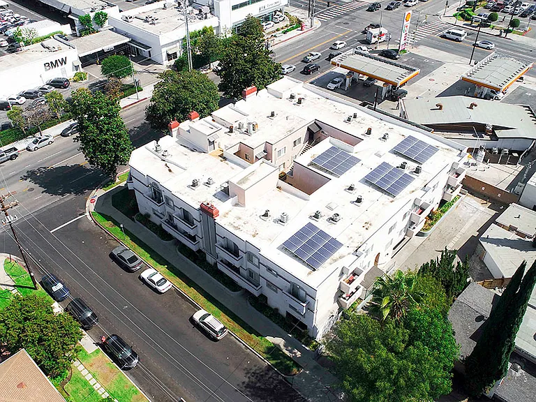 Aerial drone photo of Magnolia Terrace showing solar panels and energy-efficient white roof.