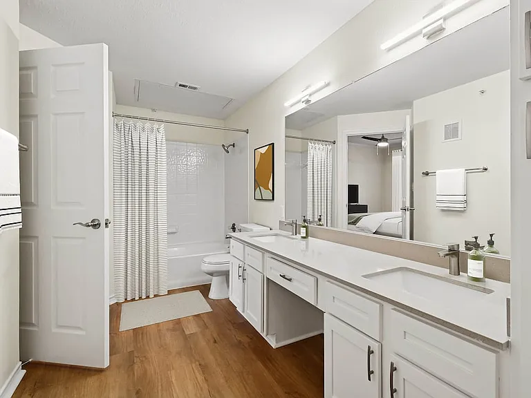 Renovated Package I bath with grey quartz countertop, white cabinetry, and hard surface flooring