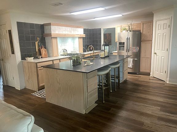 new modern kitchen with large walkin pantry, 10 foot island, new dishwasher, large sink, and barstools (view from fireplace)