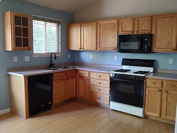 Kitchen w/laminate flooring and countertops, gas range, microwave, dishwasher and refrigerator.