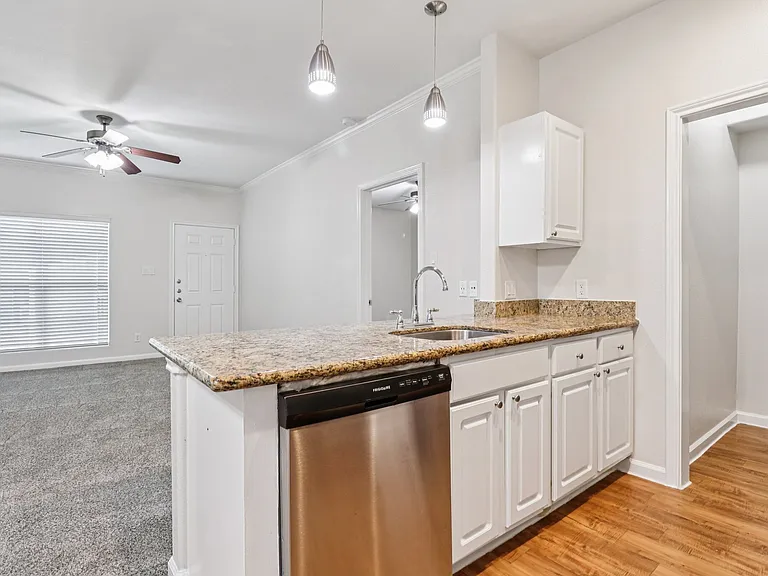 Elegant open-concept kitchen with granite countertops and stainless steel appliances, leading into a cozy, well-lit living area. Elegant open-concept kitchen with granite countertops and stainless steel appliances, leading into a cozy, well-lit living are