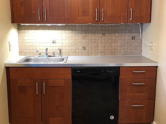 Kitchen dishwasher and lots of nice Ikea cherry finish cabinets.
