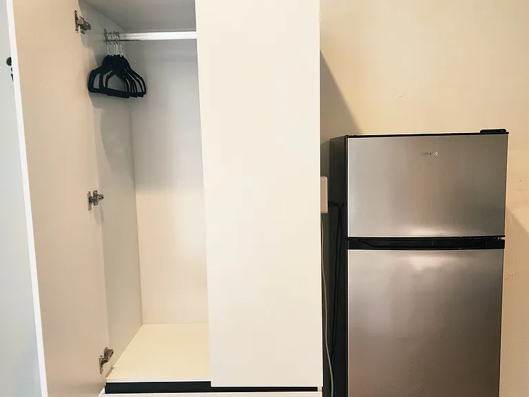 Armoire and apartment sized fridge-freezer.