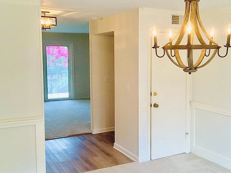 Dinning room looking into entryway and living room. Moldings and fixtures add dimension to the space.