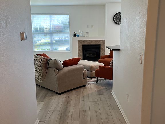 Front door entry, looking into living room. Upgraded vinyl plank flooring recently added. Tile surround gas fireplace.