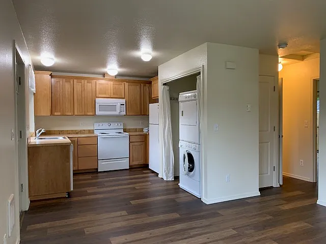 Standing in the living room looking into the kitchen. New oven range and microwave vent hood installed in 2024, not shown.