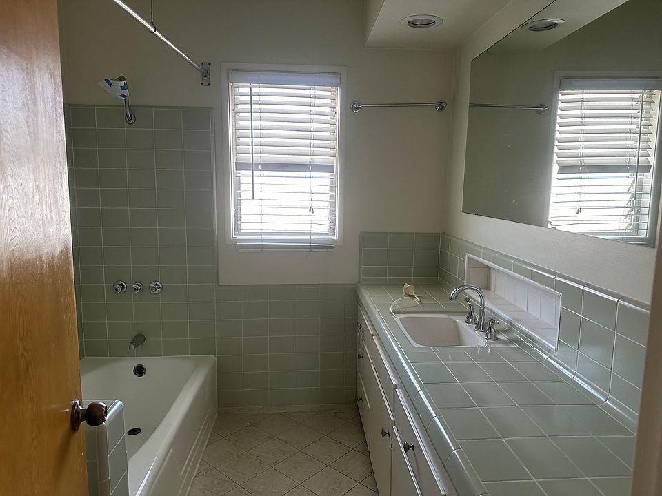 Master bathroom with great lighting, an overhead heating lamp, a long counter, a tub, and a shower.