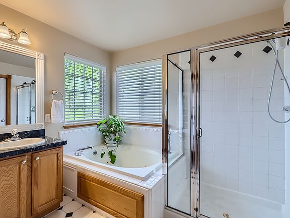 Upper Level Primary Suite 5-piece bathroom with dual sinks, jetted tub, shower, toilet and walk-in closet.