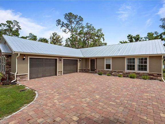 New Metal Roof, Attached oversized 2 car garage with mini split a/c system (30x25/750 sq ft), new paver driveway, Stone accents 